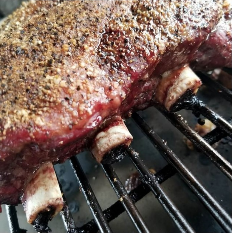 Barbecued beef "dino" short ribs on the smoker.