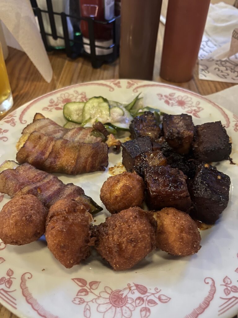 Burnt ends with cola sauce, bacon wrapped jalepeno poppers and hushpuppies at Charlotte barbecue restaurant Midwood Smokehouse.