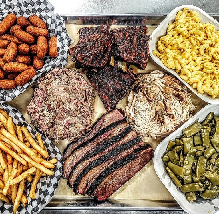 Smoked brisket, pulled pork, ribs, smoked chicken, hush puppies, macaroni and cheese, green beans and french fries make up a mighty meal at Apple City BBQ.