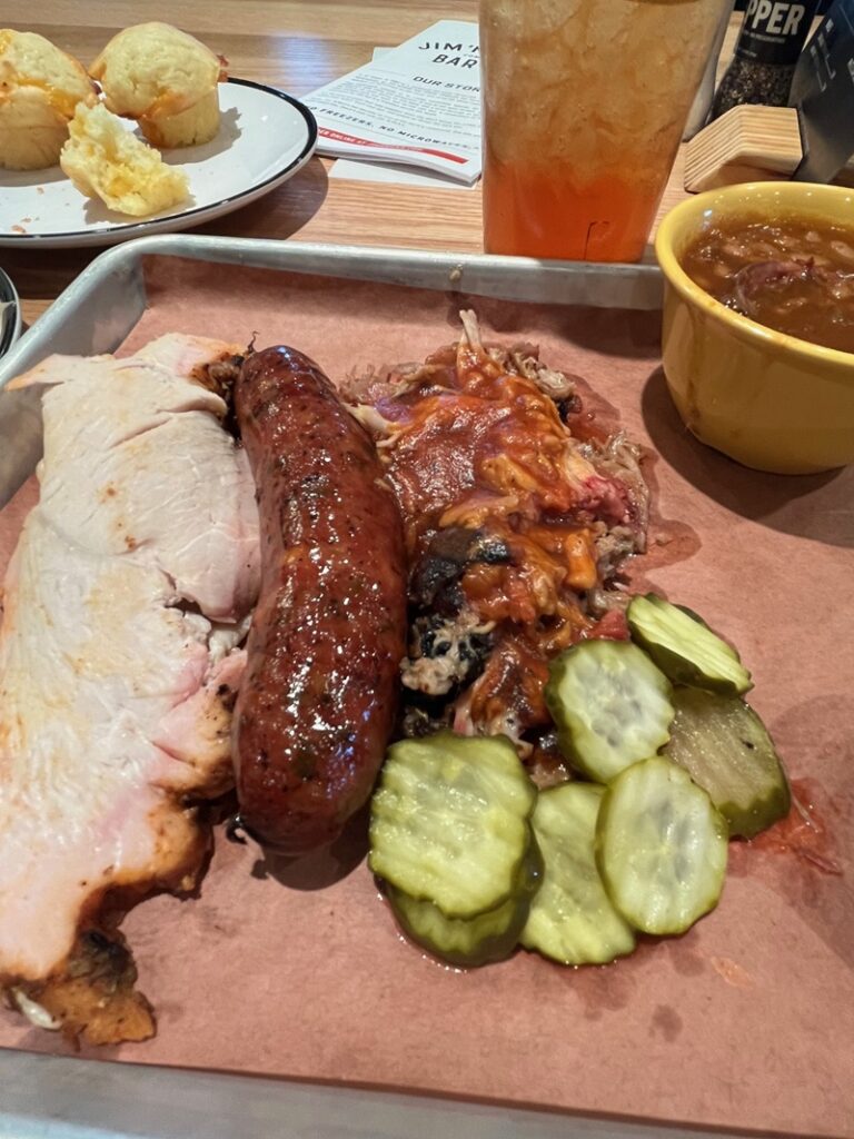 Mr. Jim's Combo Platter with smoked turkey, jalapeno + cheese sausage, "classic" pulled pork, pickles, and baked beans.