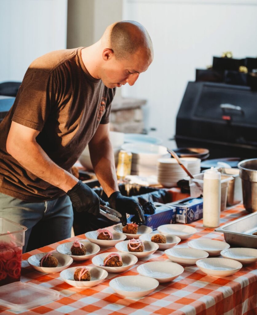 Tommie plates tasty fried bites with pickled onions during a recent catering event.